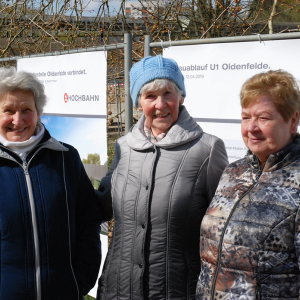 Drei Frauen stehen vor den Bauzäunen der HOCHBAHN bei der Baustelle der U1 Oldenfelde.