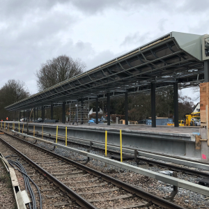 Bahngleise verlaufen zwischen einer Sichtschutzwand und dem Bahnsteig der U1 Oldenfelde.