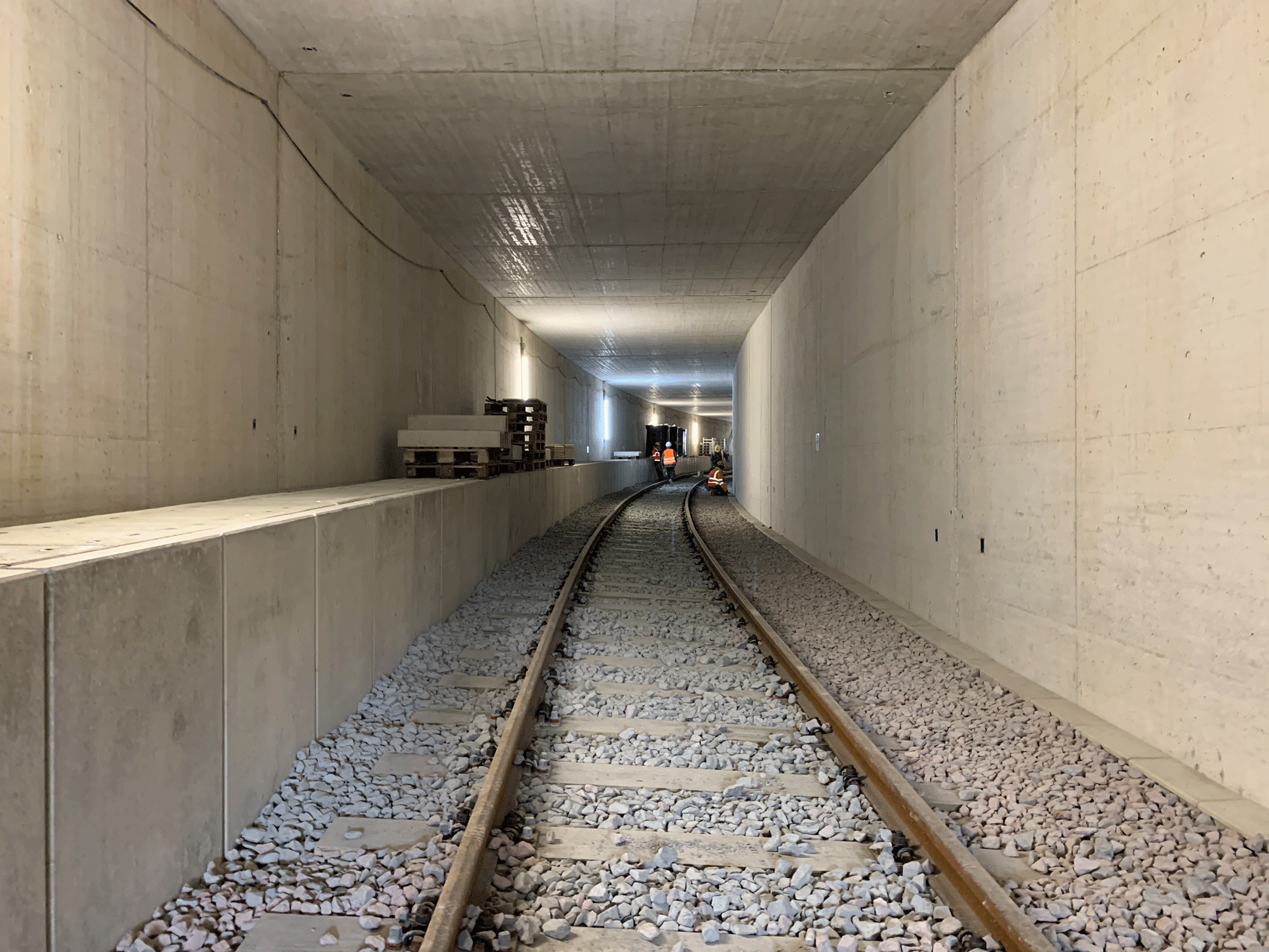 Fertiggestellter Tunnelabschnitt mit Gleisen und Schotter.