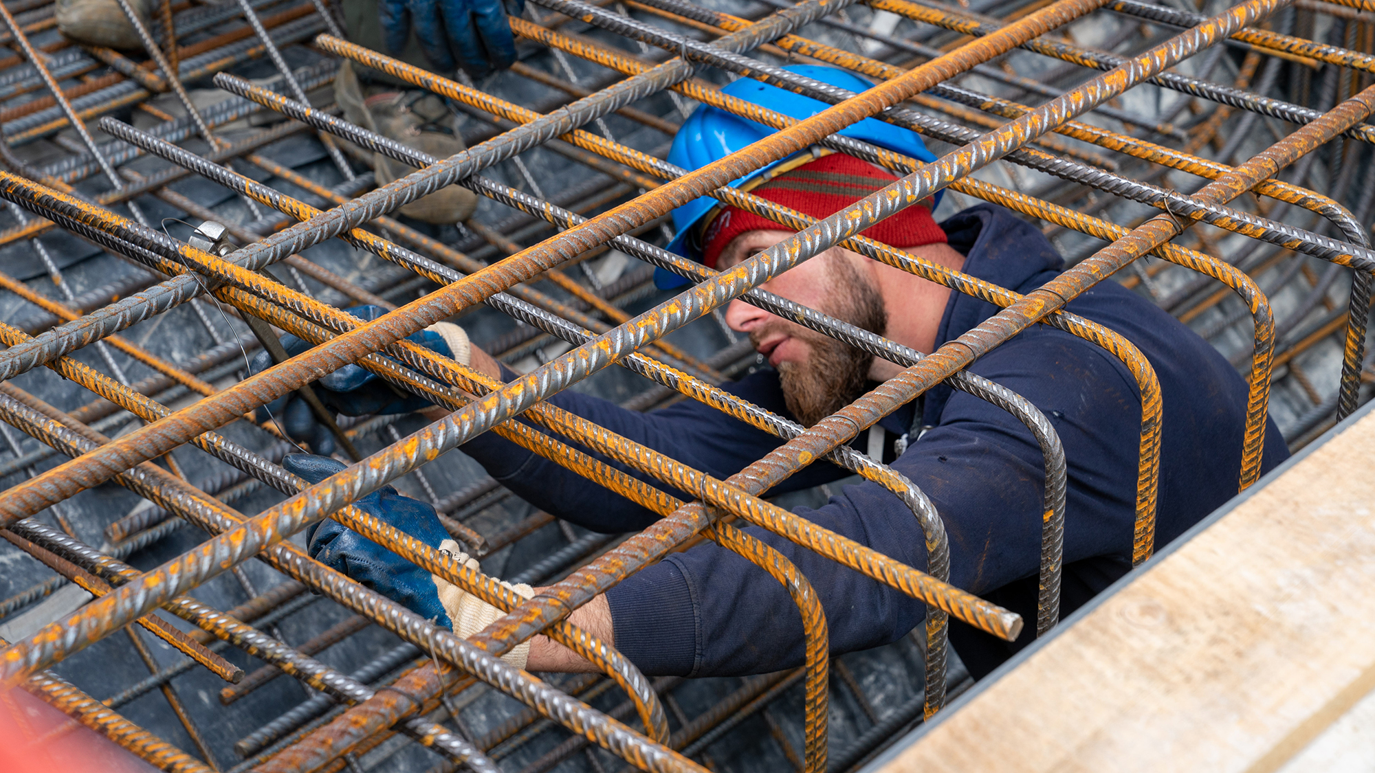 Ein Bauarbeiter arbeitet an Bewehrungskörben 