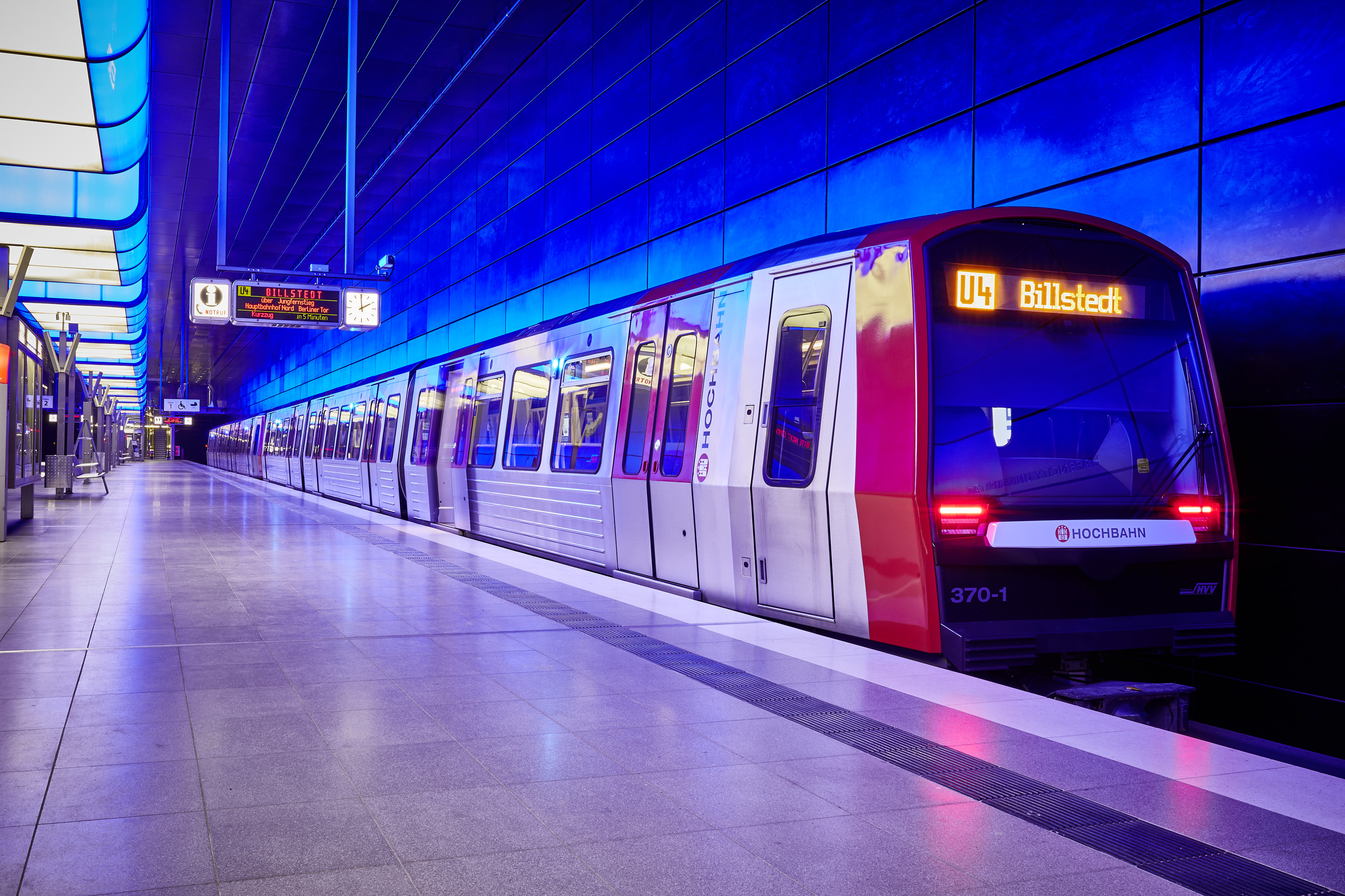 U4 U-Bahn Richtung Billstedt, stehend an einer Haltestelle. In blauem Licht. 