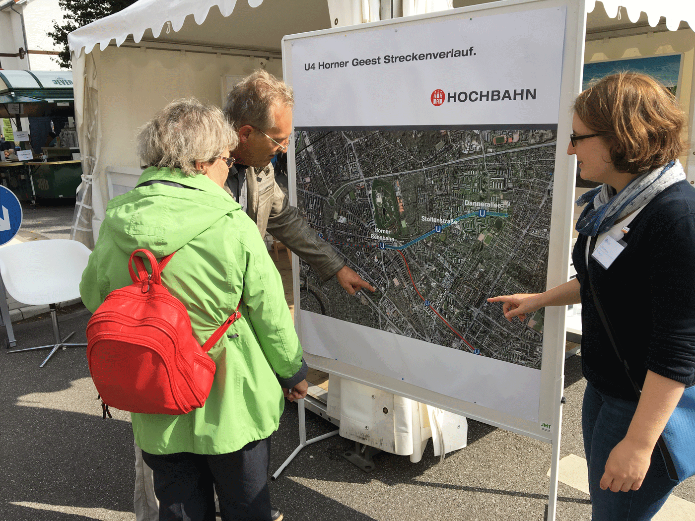 HOCHBAHN Expertin Hanna Waeselmann im Dialog mit zwei interessierten Bürger*innen.