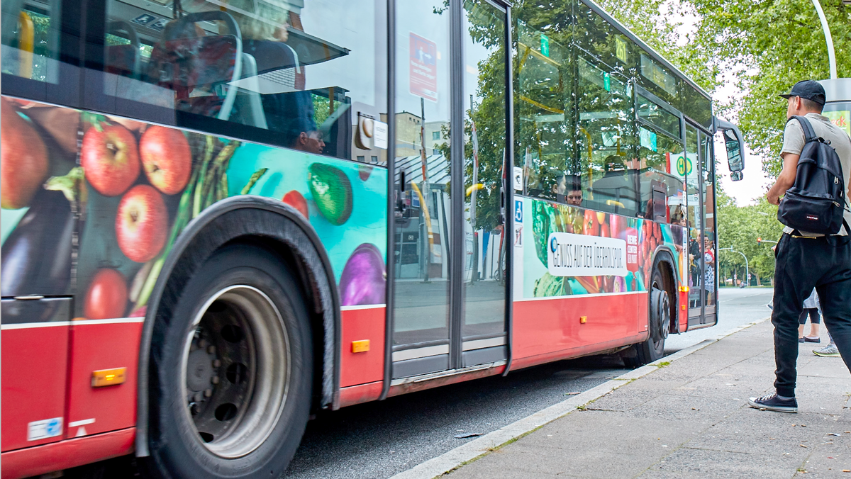 Ein HOCHBAHN Bus hält an einer Haltestelle.