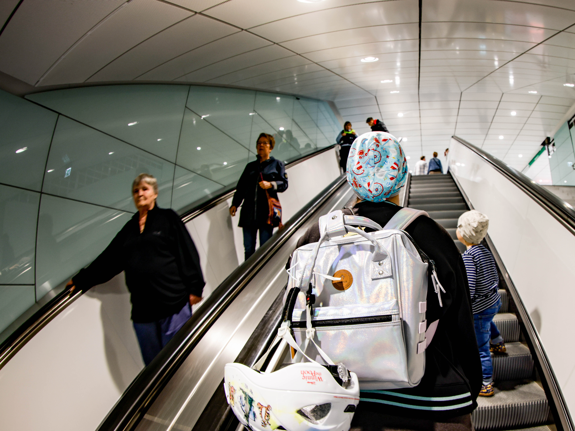 Fahrtreppe der neuen Haltestelle Horner Rennbahn. Menschen fahren nach unten und oben. 