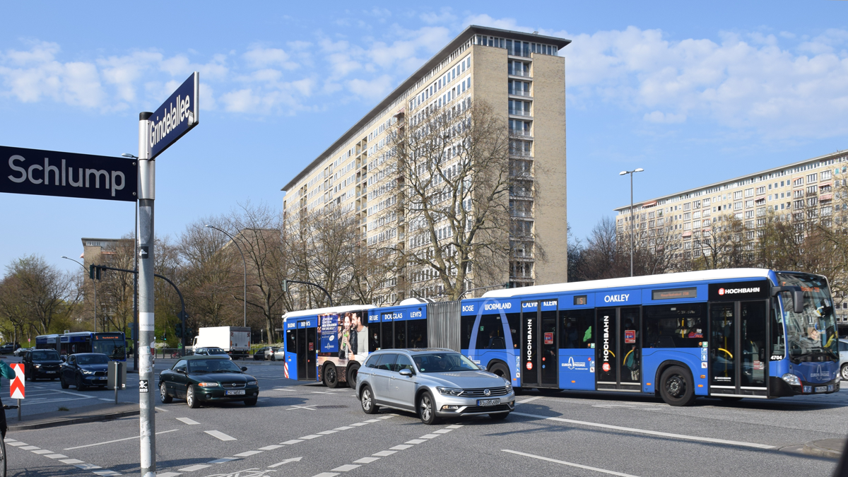 Straße mit einem Bus und Autos. Im Hintergrund mehrere Hochhäuser