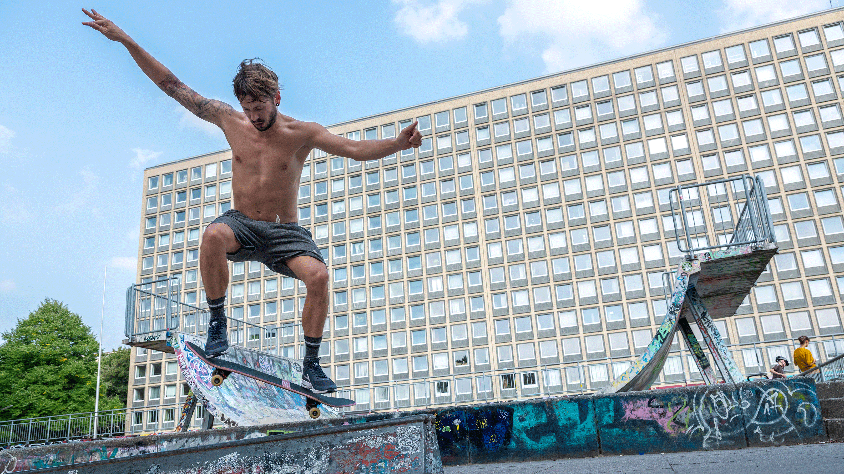 Ein Mann skatet vor den Grindelhochhäusern.