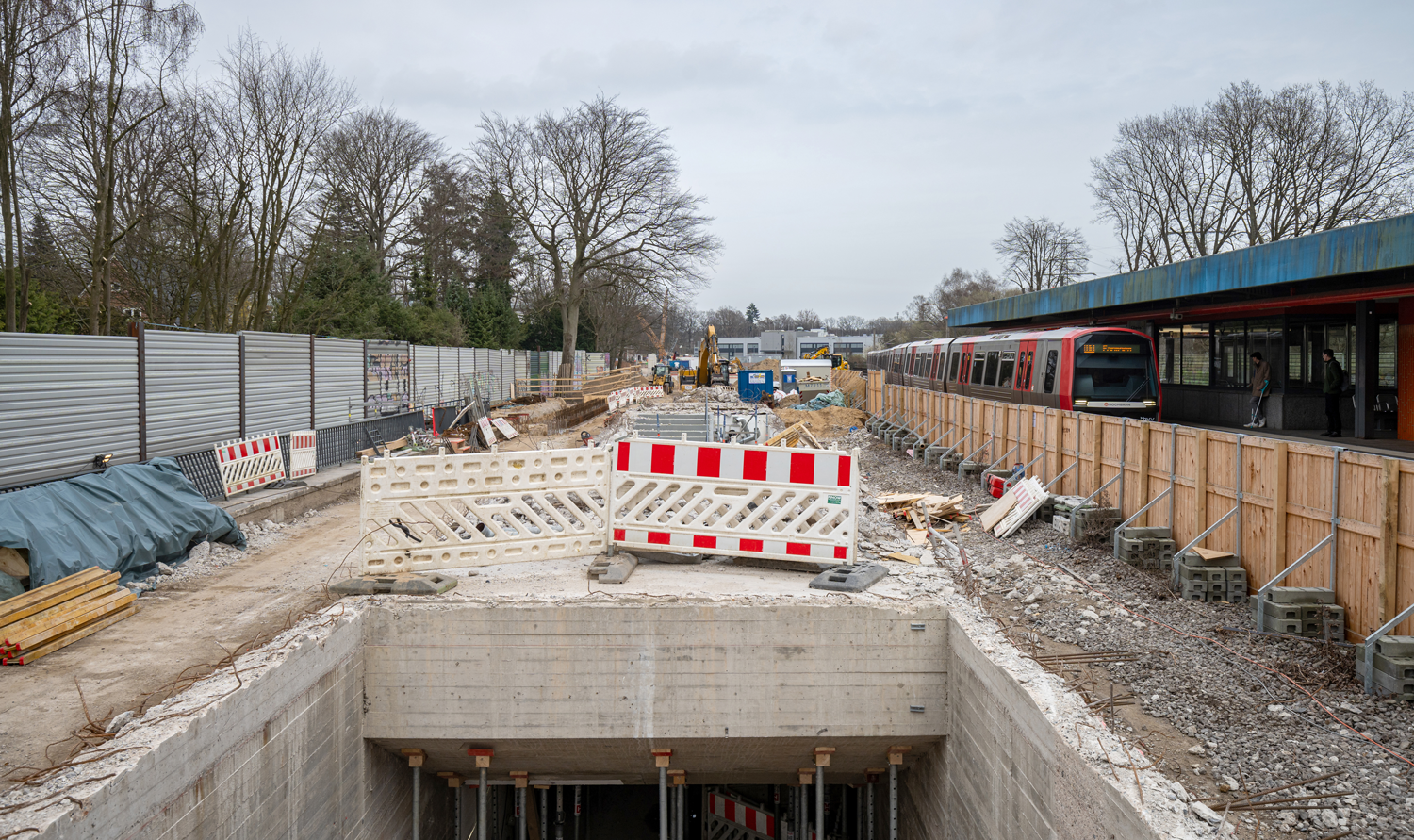 Der Alte Bahnsteig rechts neben dem Bestandsbahnsteig der U1 im Rohbau. Blick in entlang der Baustelle, Treppen nach unten. 