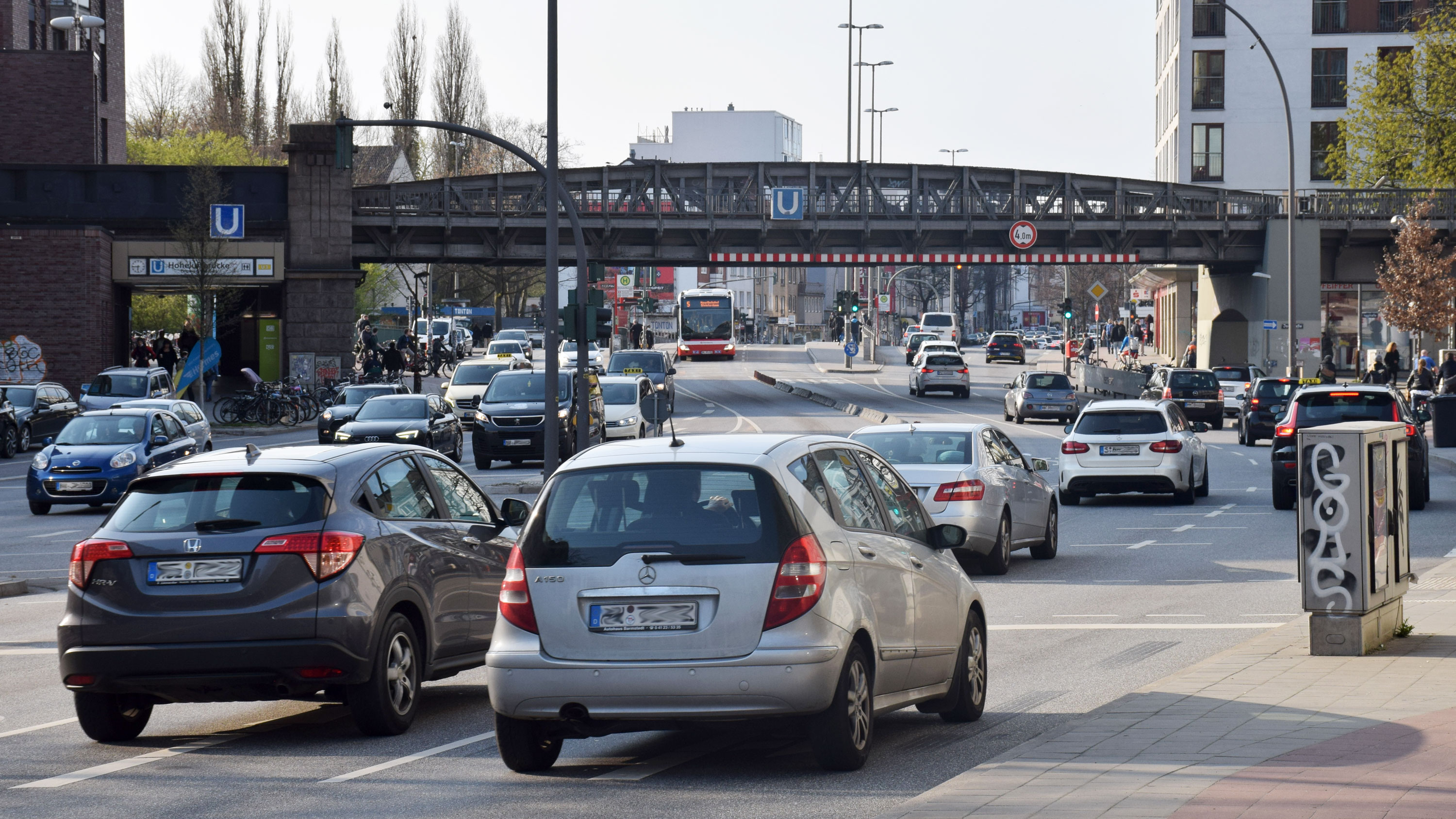 Verkehr nahe der U-Bahn-Haltestelle Hoheluftbrücke. Autos auf der Hoheluftchausee, im Hintergrund die Brücke und Teil der Haltestelle der U3