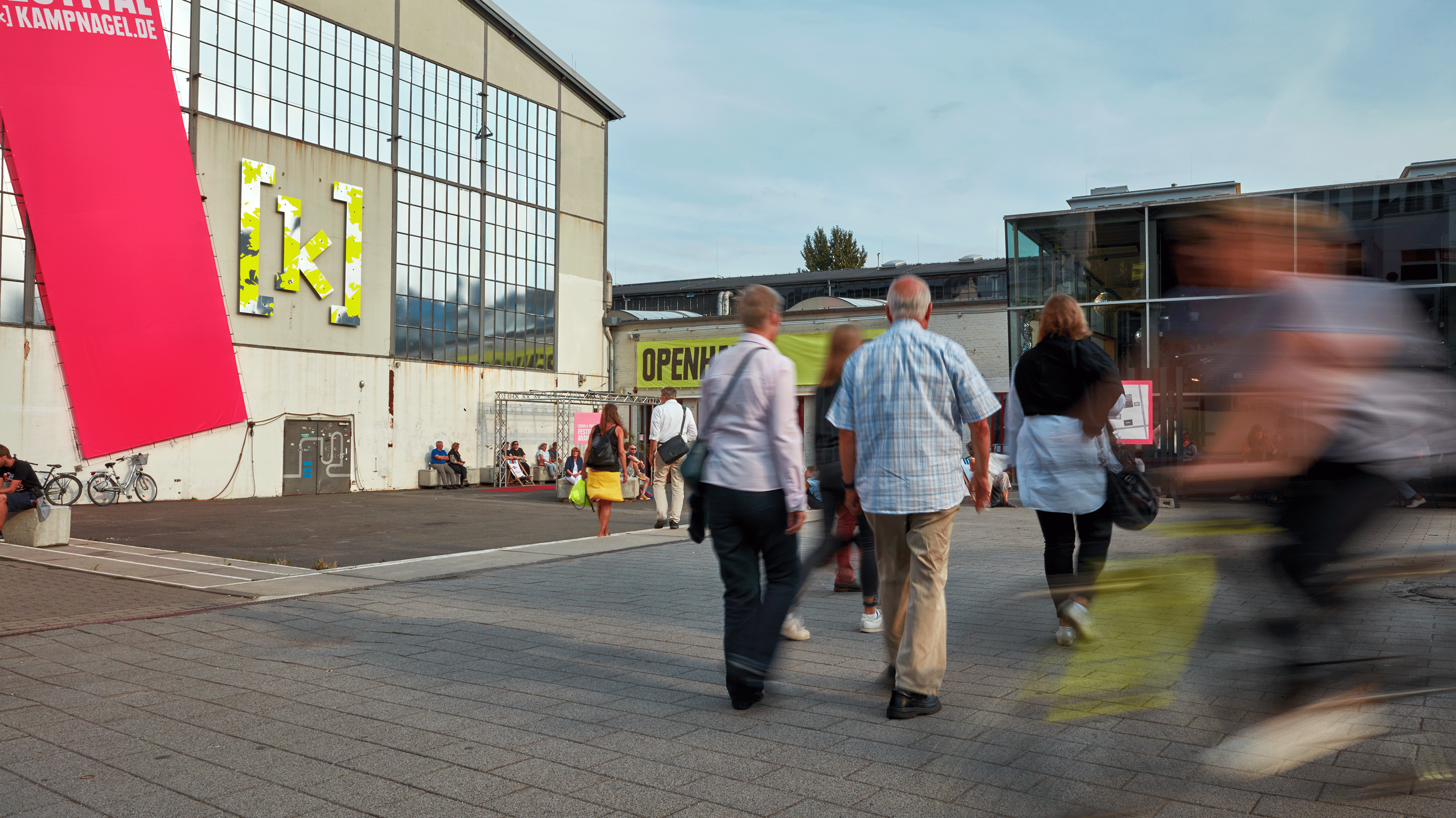 Eine Gruppe von Menschen geht in Richtung des Kampnagel-Eingangs.