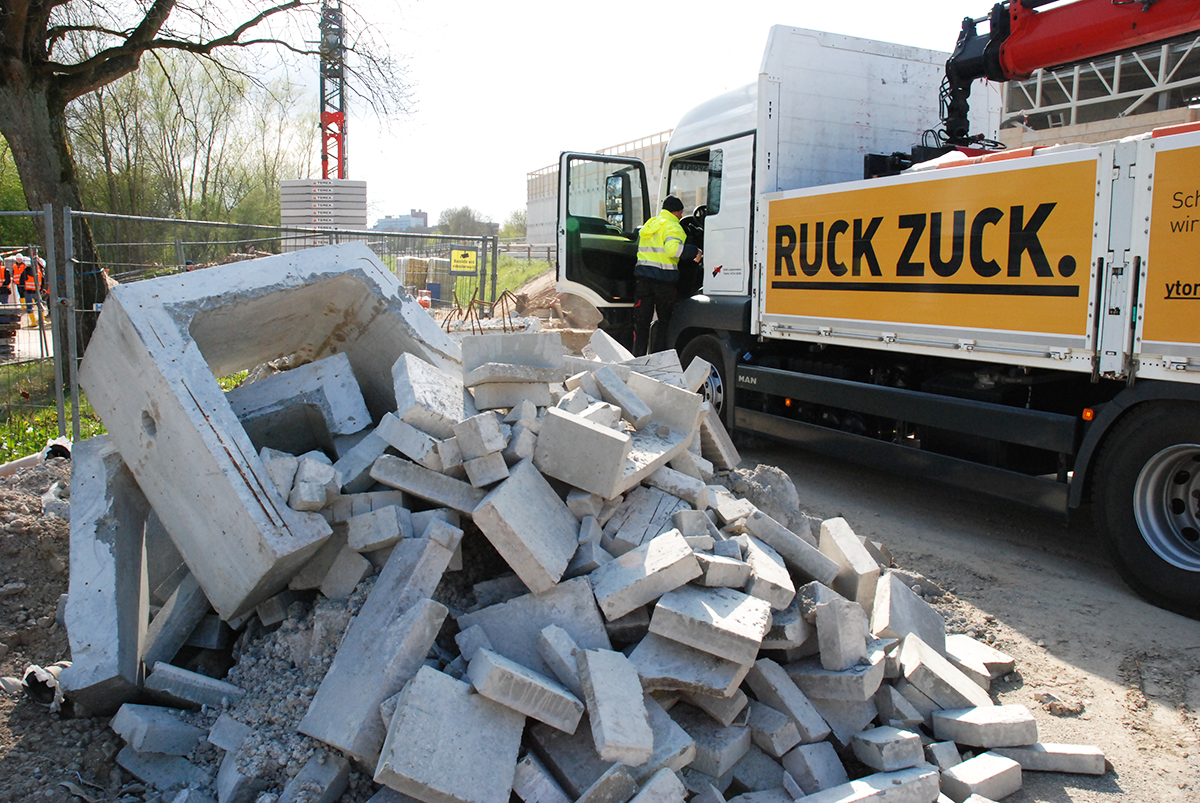 Baumaterial ist neben einem Lastwagen aufgetürmt.