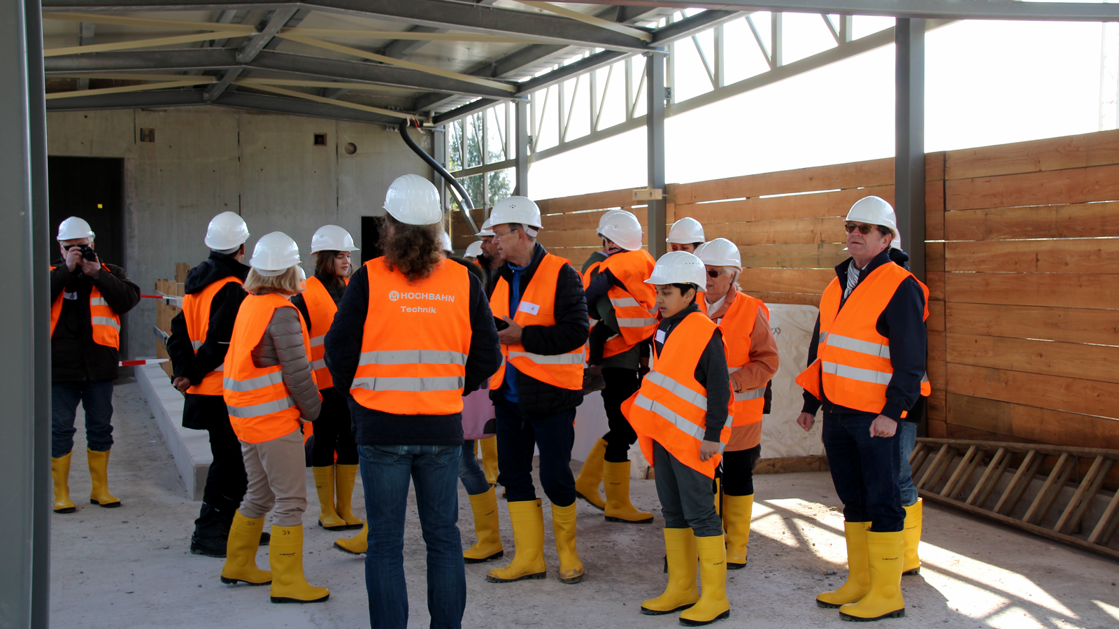 Eine Gruppe Interessierter steht in der zukünftigen Schalterhalle.