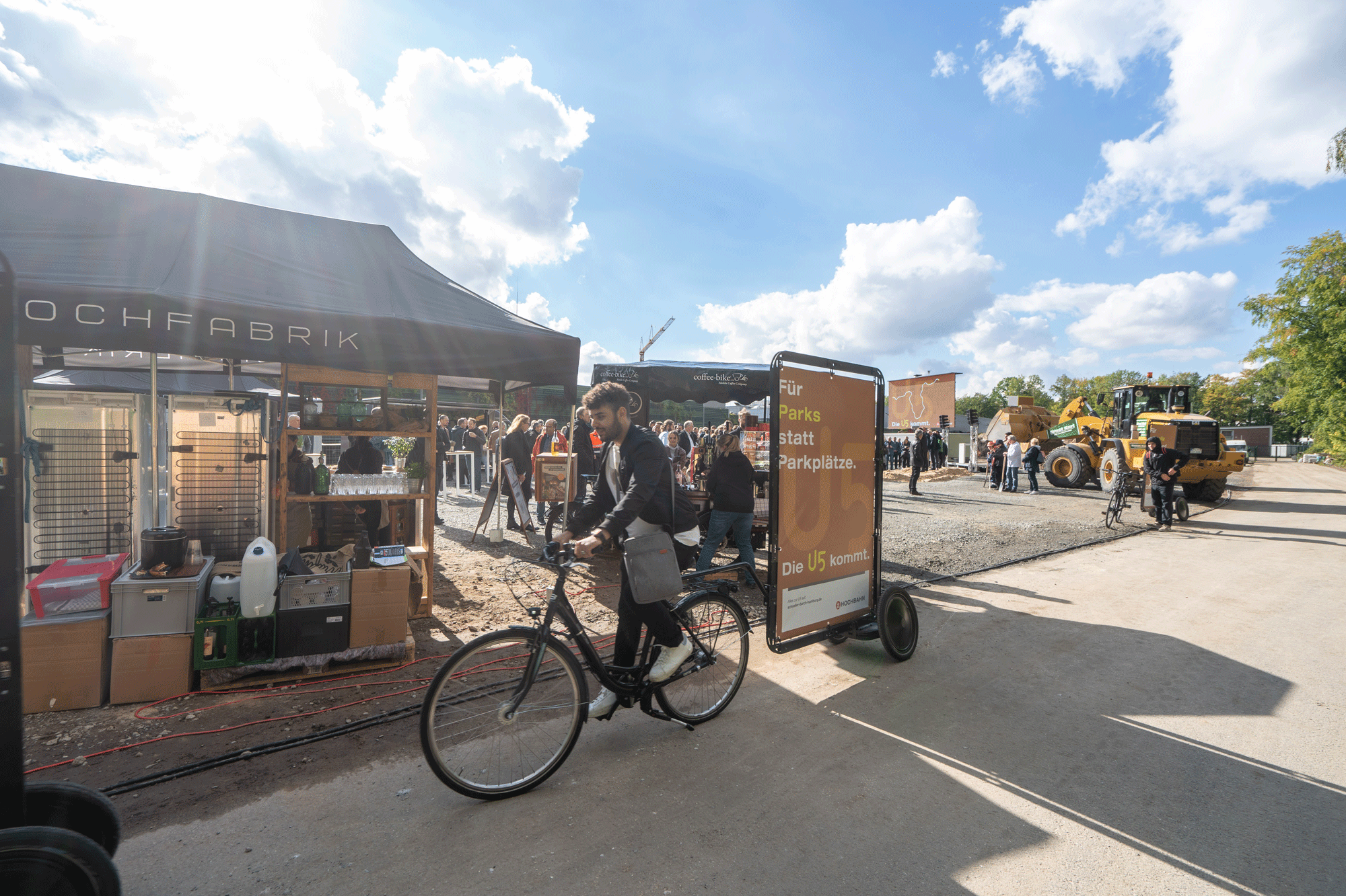 Fahrrad mit Leinwand fährt auf einer Straße neben der Baustelle