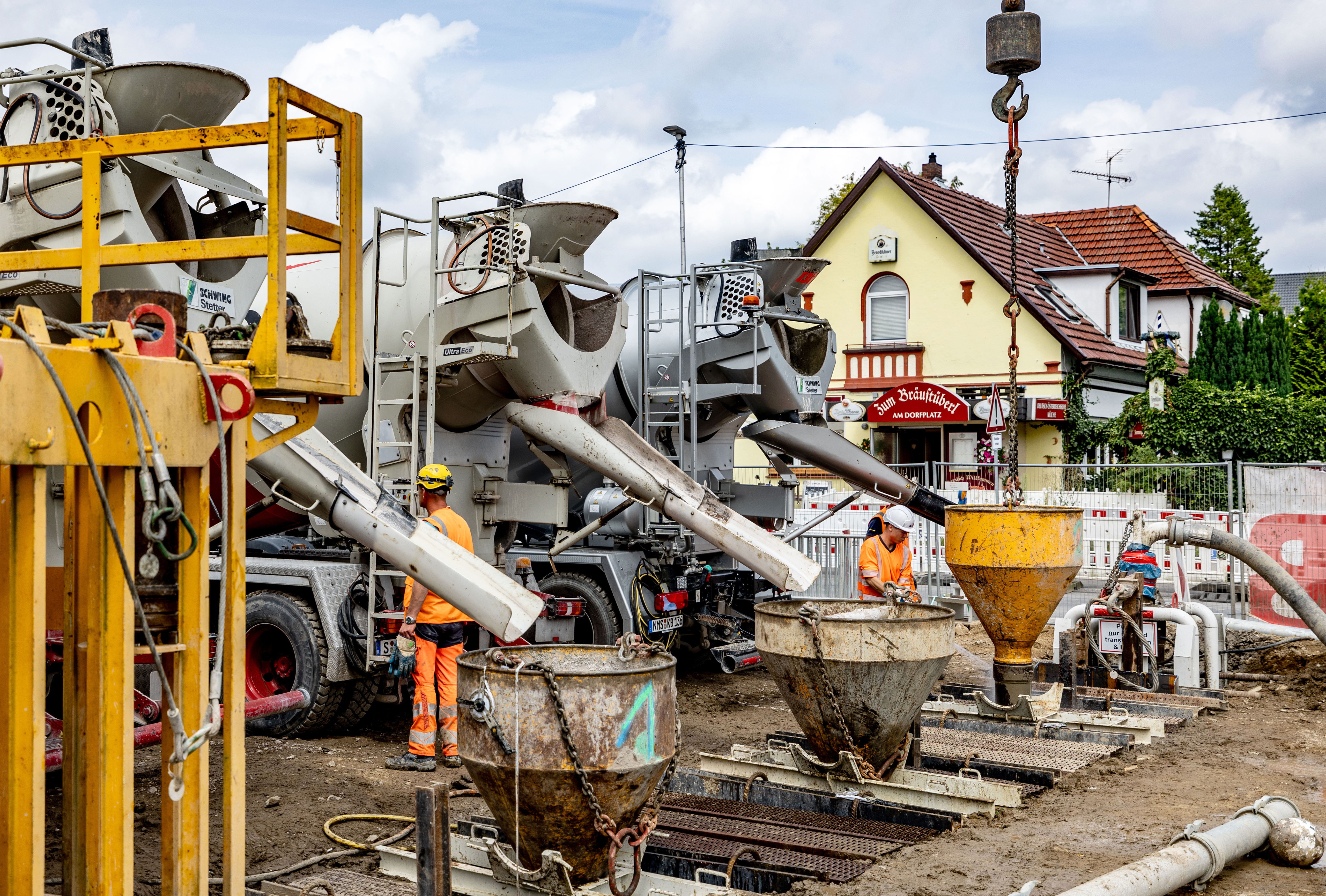 Drei Betonmischer-LKW entladen den Beton in die Schlitzwand.