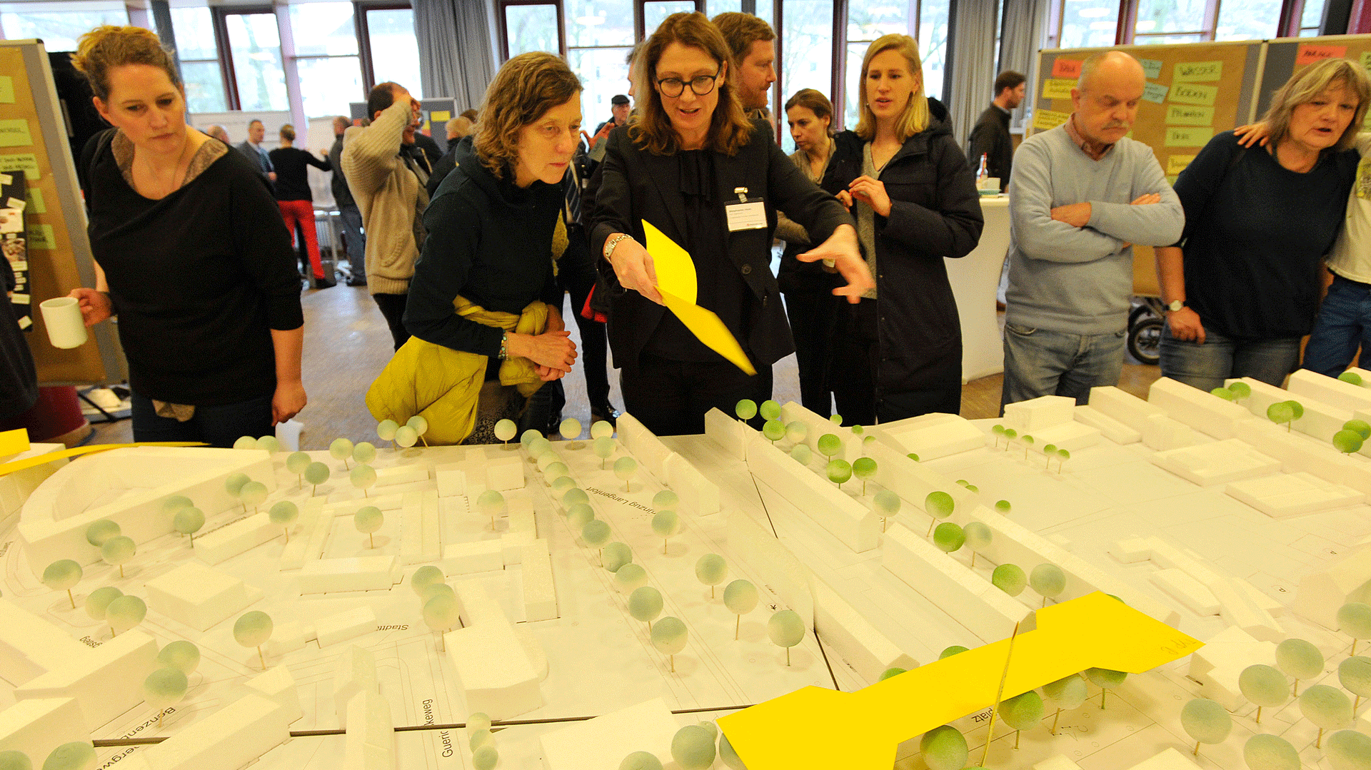 Eine Gruppe von Menschen schaut sich ein 3D Modell von Barmbek Nord an